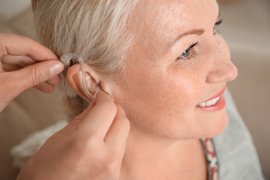 Woman having hearing aid fit to her ear