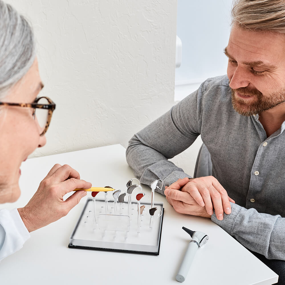 audiologist and patient looking at hearing aids